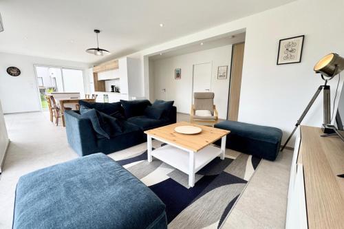 un salon avec un canapé bleu et une table dans l'établissement Maison neuve contemporaine - 10min des plages 2, à Saint-Pierre-Quiberon