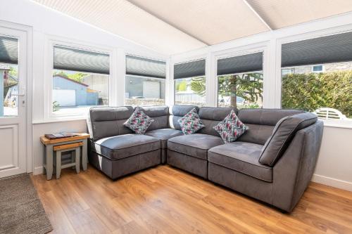 a couch in a living room with windows at Atholl Villa Guest House in Pitlochry