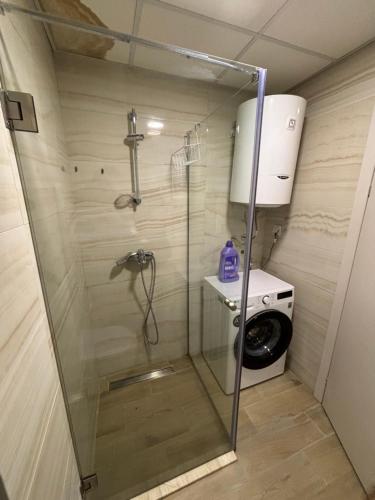 a shower in a bathroom with a washing machine at City Center Apartment 2 in Skopje