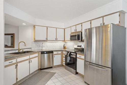 a kitchen with white cabinets and stainless steel appliances at Ozark Retreat at the Pointe in Branson
