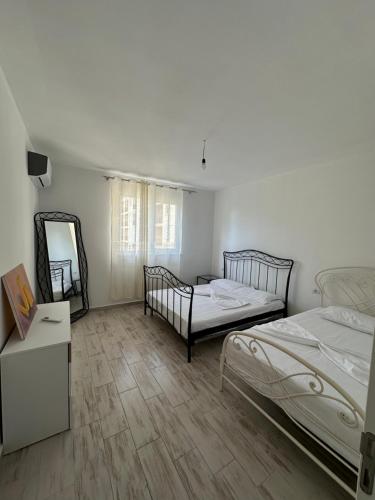 a white room with two beds and a mirror at Casa Del Mar in Shëngjin