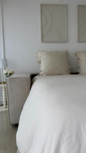 un lit avec des draps blancs et des oreillers dans une chambre dans l'établissement Studio à 50 m de la plage, à Canet