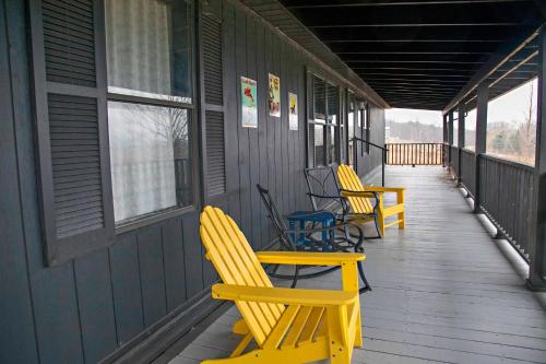 a porch with yellow rocking chairs on a house at Purple Parrot in Hammondsport