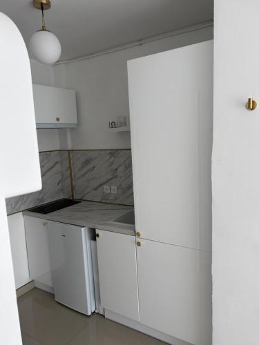 une cuisine avec des armoires blanches et un comptoir dans l'établissement Studio à 50 m de la plage, à Canet