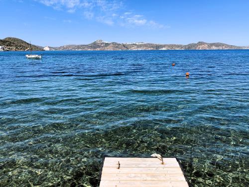 a dock in a large body of water with a boat at Manos' Dream in Empourios