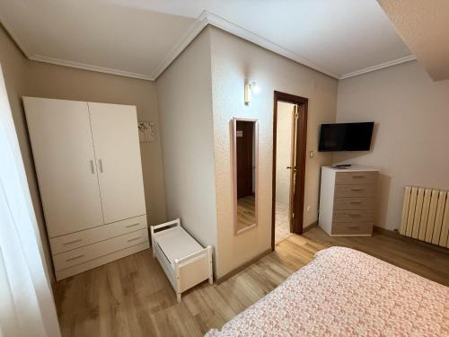1 dormitorio con cama, tocador y espejo en Hostería El Cruce, en Cabezón de la Sal