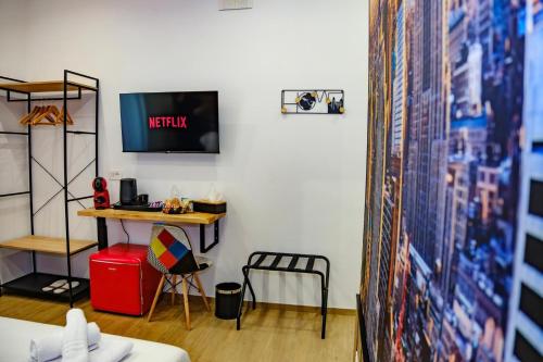 a room with a desk and a tv and a table at Futura Guest House in Bari