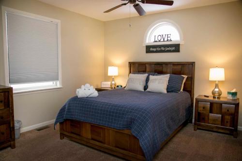 a bedroom with a bed with a blue blanket and a window at Lodge on Lamoka 