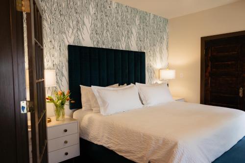 a bedroom with a bed with a black headboard and white pillows at Hotel Pontotoc in Memphis