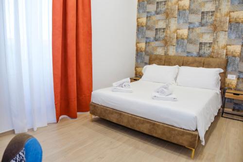 a bedroom with a bed with white sheets at Futura Guest House in Bari