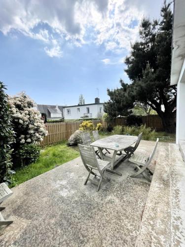 une table et des chaises assises sur une terrasse dans l'établissement Maison de charme - Proche plages et bourg, à Larmor-Plage