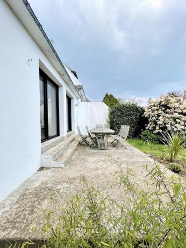 un patio avec une table et un banc à côté d'un bâtiment dans l'établissement Maison de charme - Proche plages et bourg, à Larmor-Plage