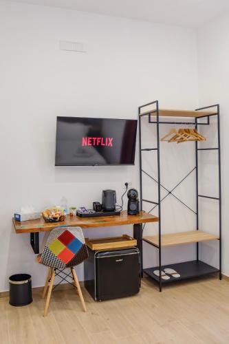 a desk and a shelf with a netflix sign on a wall at Futura Guest House in Bari