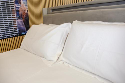 two white pillows sitting on a bed in a room at Futura Guest House in Bari