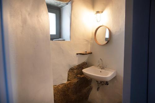 a bathroom with a sink and a mirror at Under The Linden Tree Tinos in Xinára