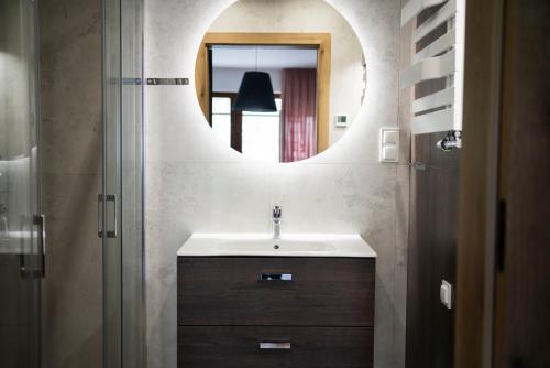 ein Badezimmer mit Waschbecken und Spiegel in der Unterkunft Willa Matejki - Apartament 7 in Przemyśl