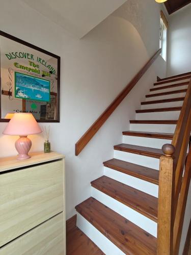 a staircase in a house with a lamp and a dresser at Erin House - Oughterard Central in Oughterard