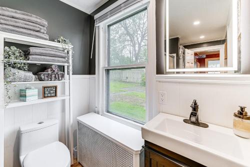 a bathroom with a toilet and a sink and a window at Near Lake and Wineries Spacious Union Springs Home! 