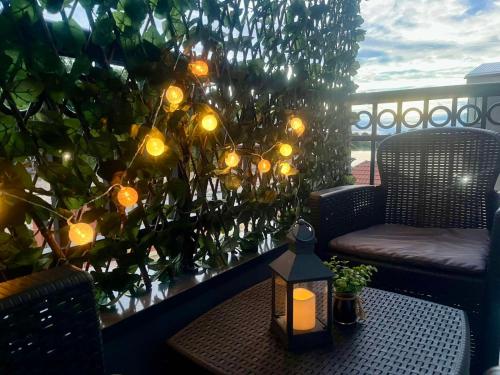 a table with a candle on a balcony with lights at Apartman 3N in Veliko Gradište