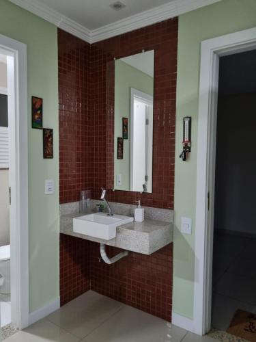 um banheiro com pia e espelho em GOLDEN LAKE, lugar para relaxar em Arraial do Cabo