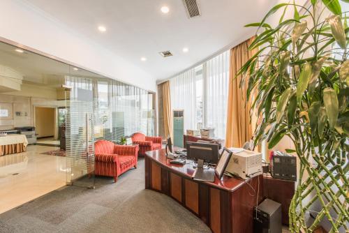an office with a desk with a computer and red chairs at Beijing Asia Pacific Garden Hotel in Tongzhou