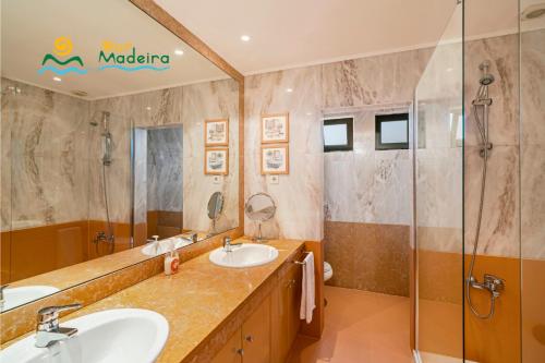 a bathroom with two sinks and a shower at OurMadeira - Villa Luz in Funchal