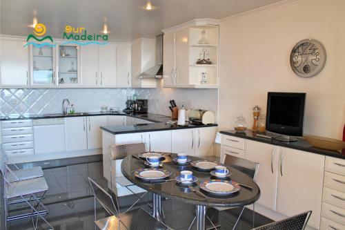 a kitchen with a table with plates on it at OurMadeira - Villa Luz in Funchal