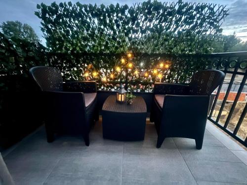 a patio with chairs and a table and lights at Apartman 3N in Veliko Gradište