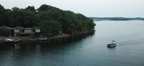 a small boat in a large body of water at Lakefront Treetop Village 2bd3badeckpool-6pp in Four Seasons