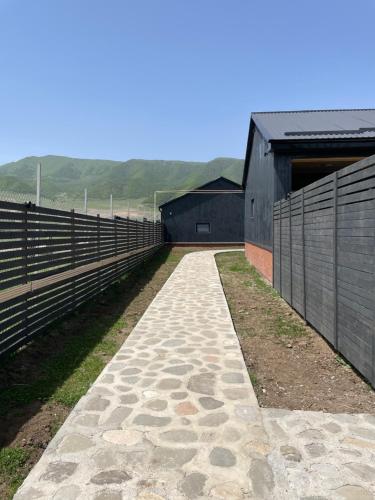 a walkway next to a barn with a fence at Shahdag Berghoff House in Qusar