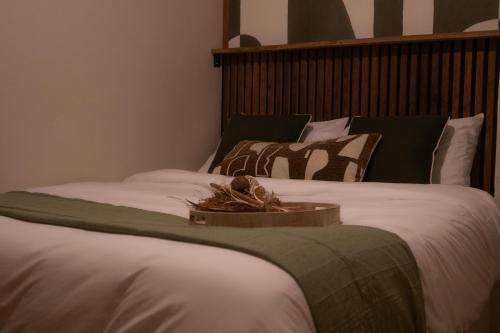 セリニャンにあるLe Japandi - appartement cosy & friendlyの白いシーツとボウルが置かれたベッドが2つ