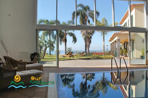 a house with a swimming pool with a view of the ocean at OurMadeira - Villa Luzia in Funchal