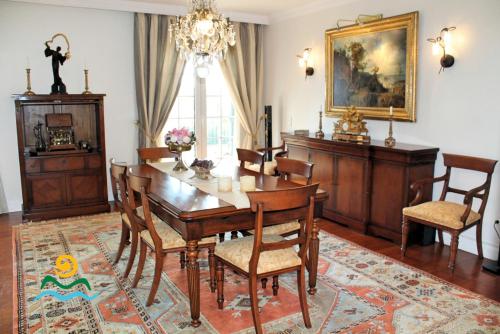 a dining room with a wooden table and chairs at OurMadeira - Villa Luzia in Funchal
