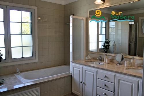 a bathroom with a tub and a sink at OurMadeira - Villa Luzia, luxury in Funchal