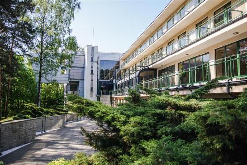 a building with a sidewalk in front of a building at Apartament w Sosnowym SPA in Serock
