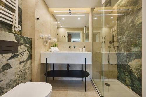 a bathroom with a sink and a shower at Golden Hour Apartments- Loft H 418 in Świnoujście