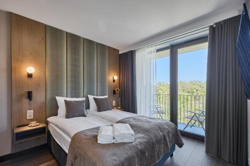 a hotel room with a bed and a balcony at Golden Hour Apartments- Loft H 418 in Świnoujście