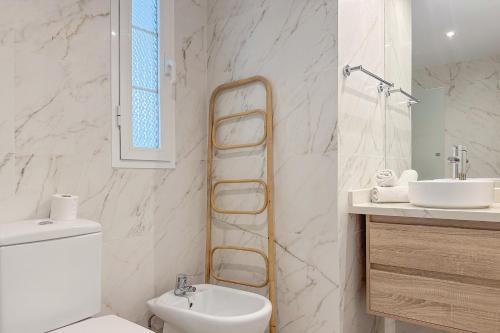 a bathroom with a toilet and a sink and a mirror at El Veril del Duque Apartment in Adeje