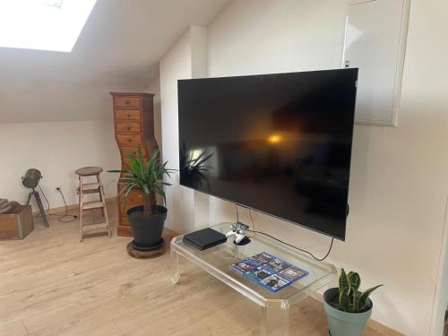 a living room with a large flat screen tv on the wall at Soirée privée in Alès