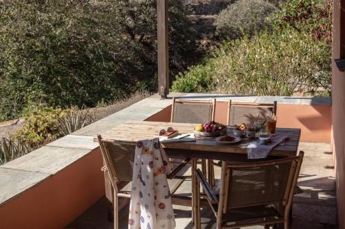 a wooden table with a bowl of fruit on a patio at Under The Linden Tree Tinos in Xinára
