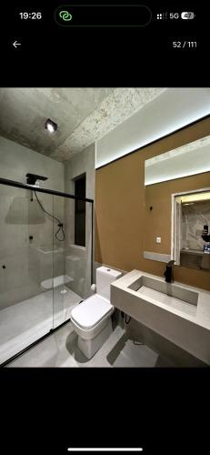 a bathroom with a toilet and a sink and a shower at Casa Cedro in Espera Feliz