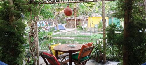 a patio with a table and chairs in a garden at Chalés da Cris in Fortim