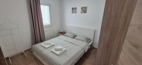 a bedroom with a bed with two white pillows on it at Apartment Magdalena in Sveti Filip i Jakov