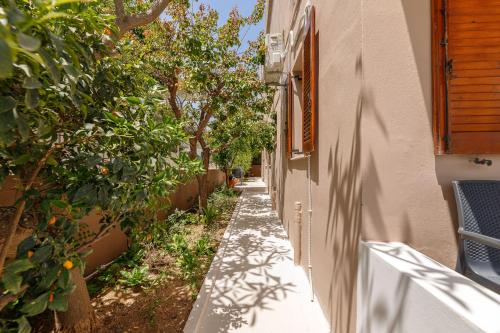 a narrow alley with trees and a building at Lyria Hotel Apartments in Stalos
