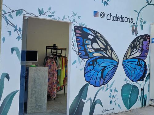 a room with butterflies painted on the wall at Chalés da Cris in Fortim