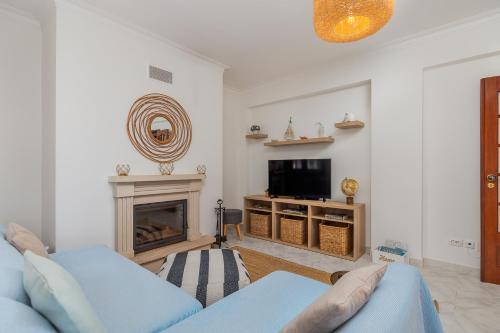 a living room with a blue couch and a fireplace at Breeze Beach House in Setúbal