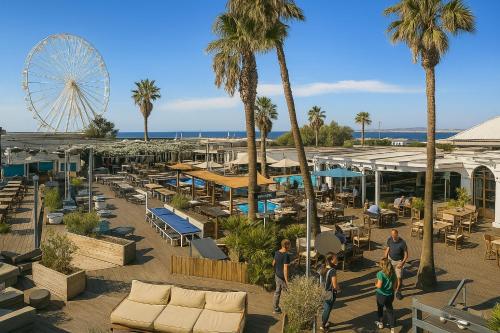 des gens se promenant dans un complexe hôtelier avec une grande roue dans l'établissement Appartement T3 72m2 Marselle St Anne Borély Proche plage, à Marseille