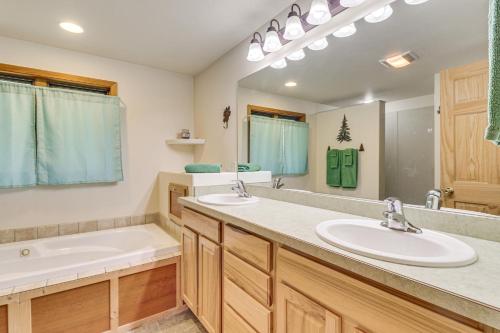 a bathroom with two sinks and a large mirror at Scenic Forest Lodge Outside Glacier National Park! in West Glacier