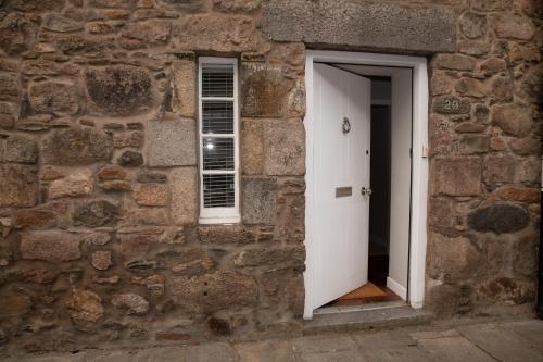 an open door in a stone building with a window at Snow Cottage, Old Aberdeen, 3 bedroom luxury in Aberdeen