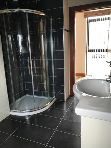 a bathroom with a shower and a tub and a sink at Serene Luxurious Haven with Sea Views Letterkenny Rooms in Letterkenny